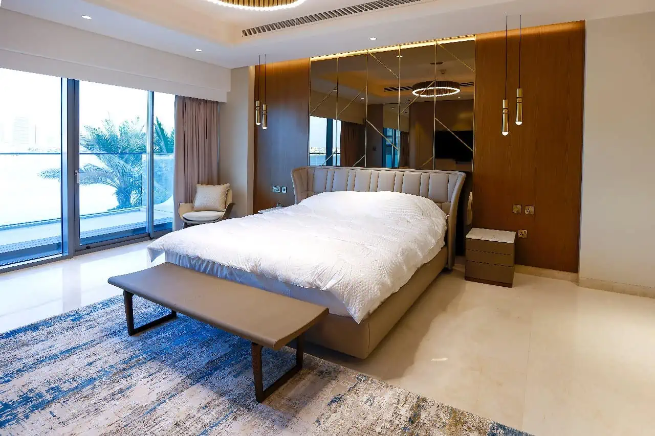 a bedroom with a large bed and a mirror wall