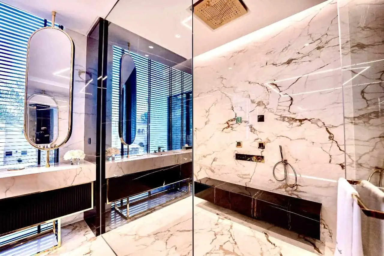 a bathroom with marble walls and a large mirror