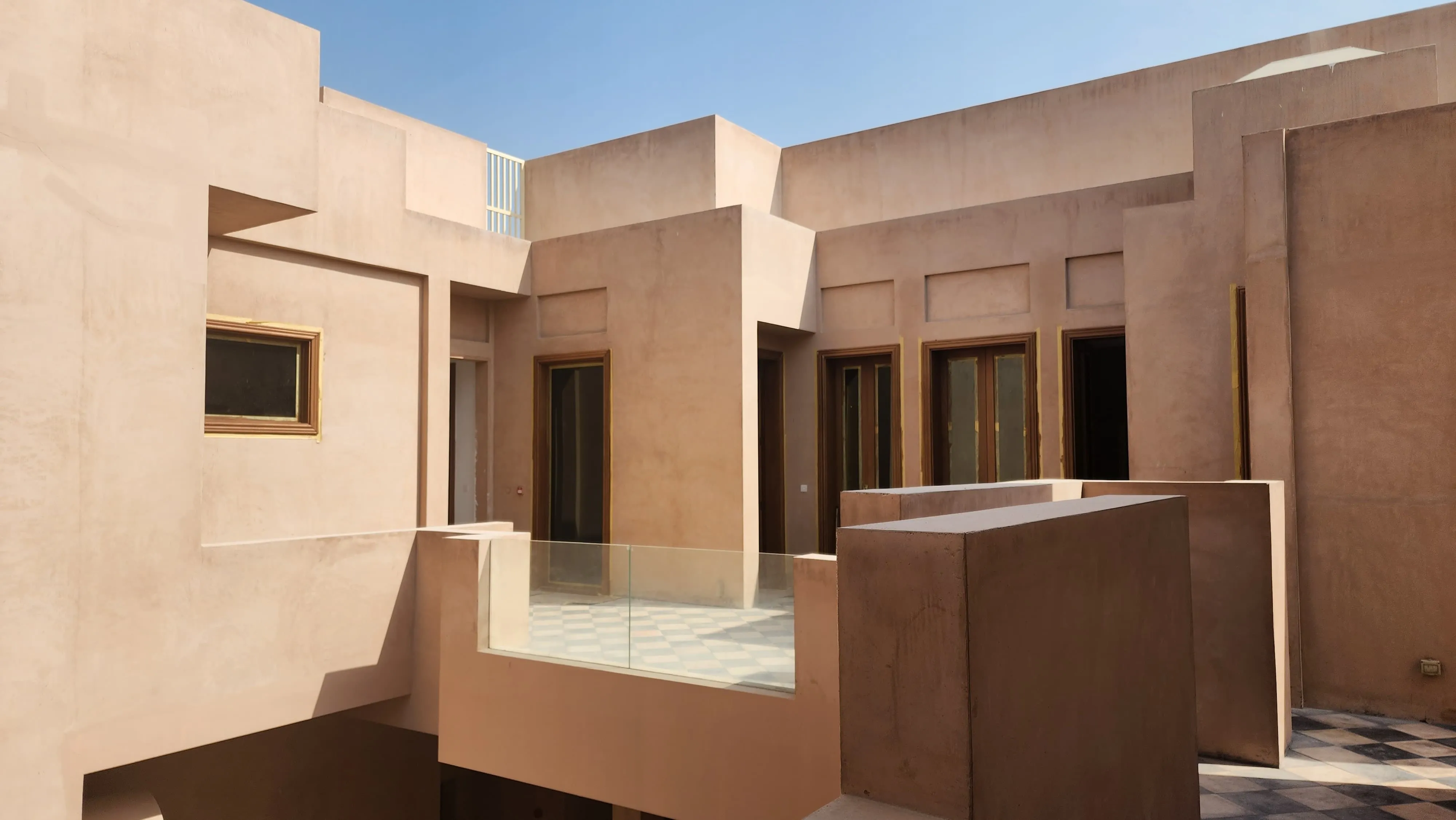 A tranquil courtyard with tan concrete, creating a warm and welcoming atmosphere.