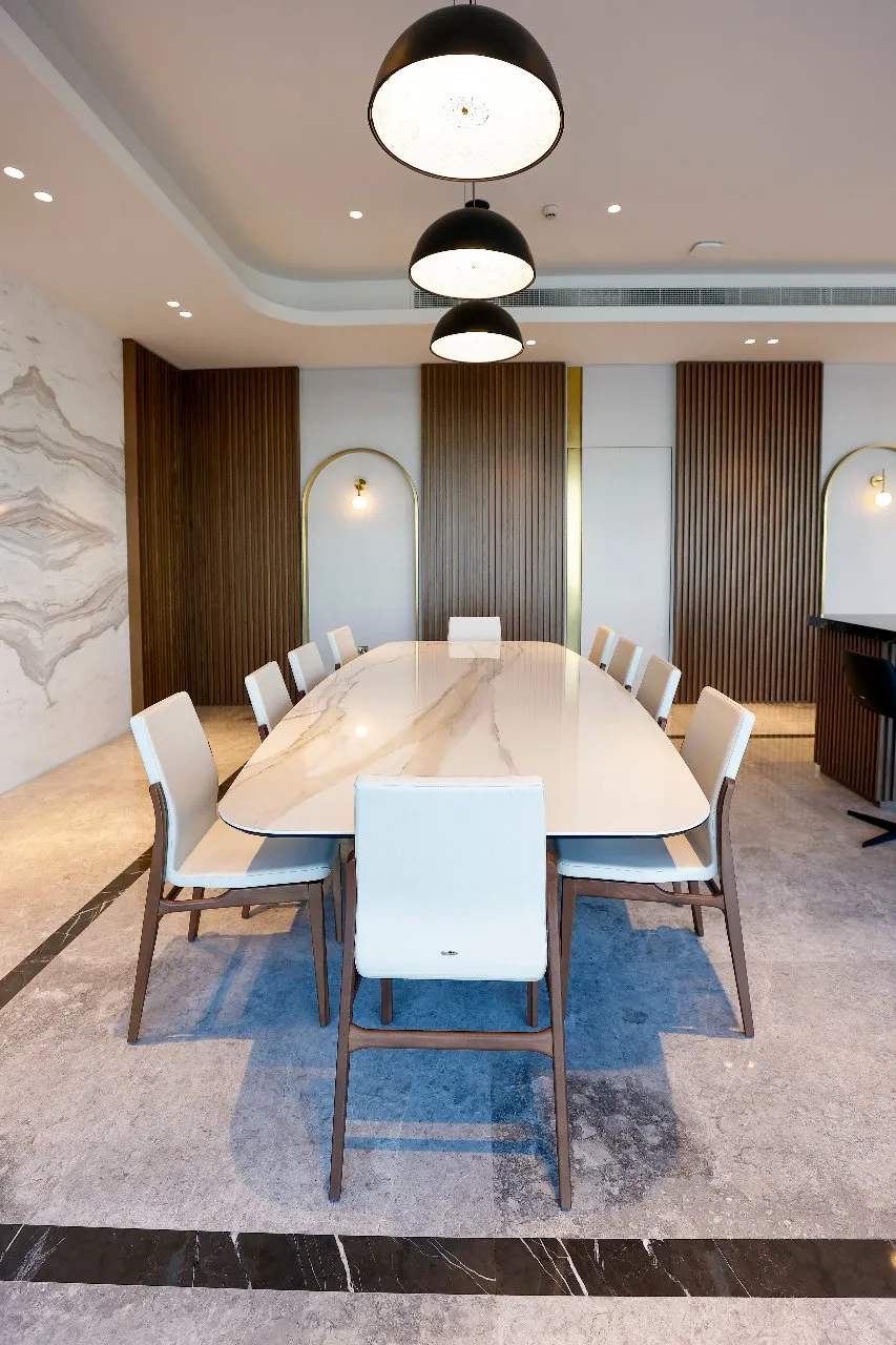 A luxurious white marble dining table with white chairs 