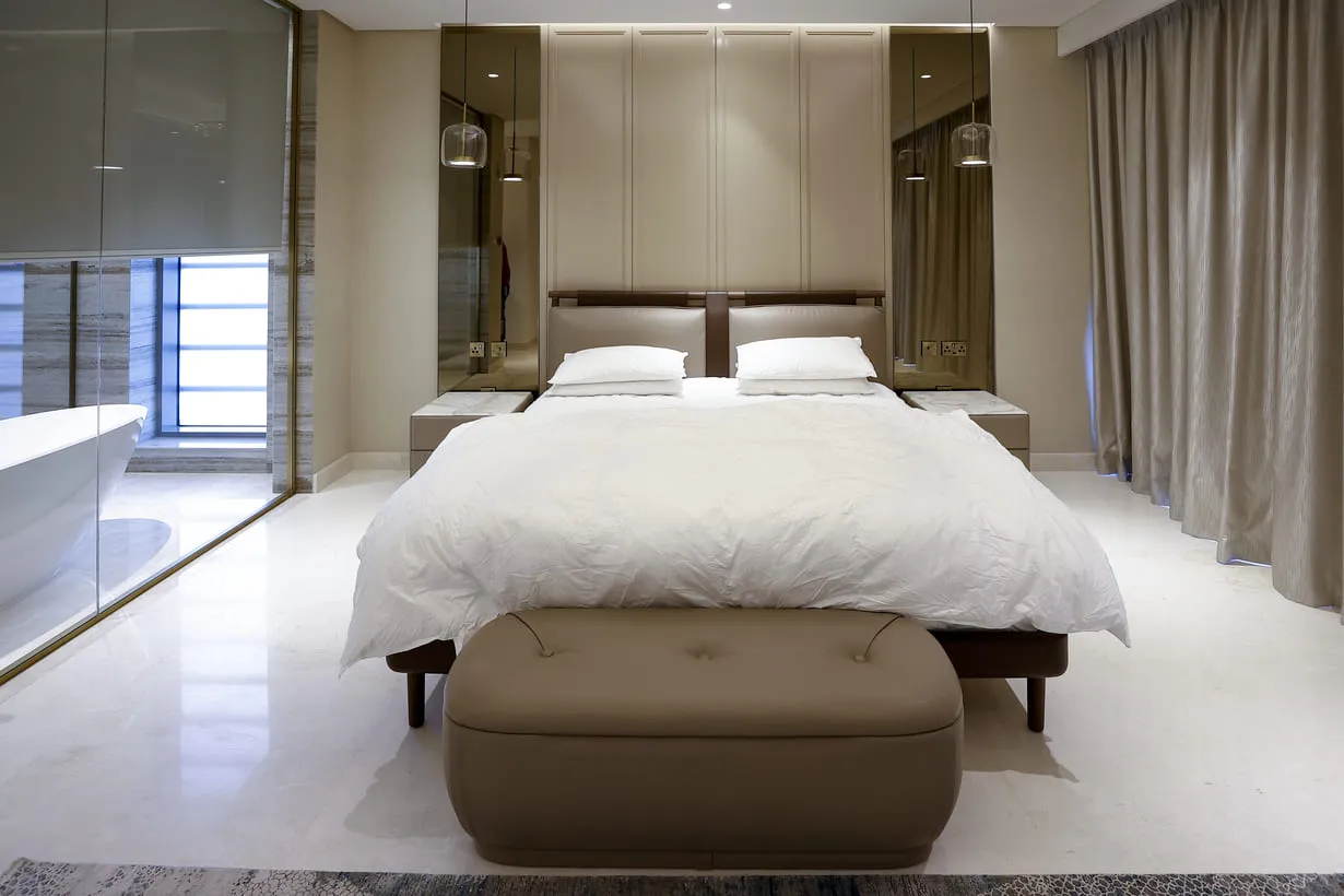 a bed with a foot stool in a room