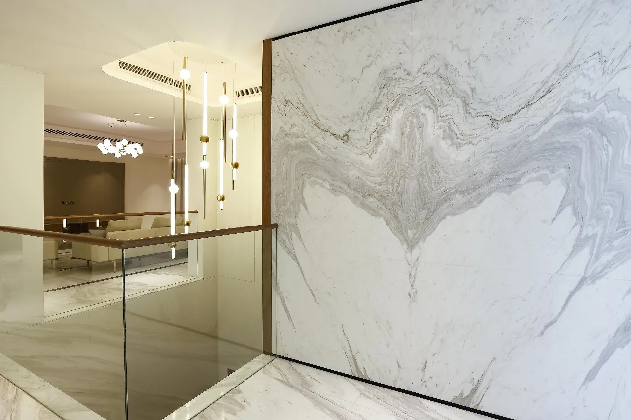 A modern home with a marble wall and glass railing, creating a sleek and sophisticated ambiance.