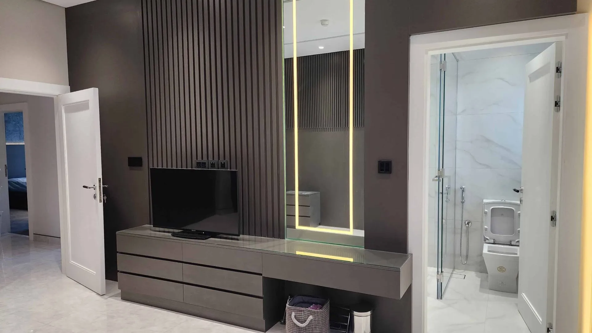 A modern bathroom with a TV and mirror, creating a luxurious and convenient space for relaxation and grooming.